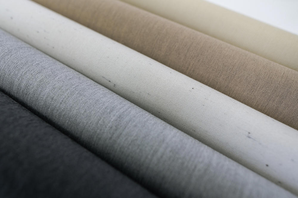 Različni vzorci in barve visokokakovostnih tkanin za tende – od temno sive do svetlo bež odtenkov.