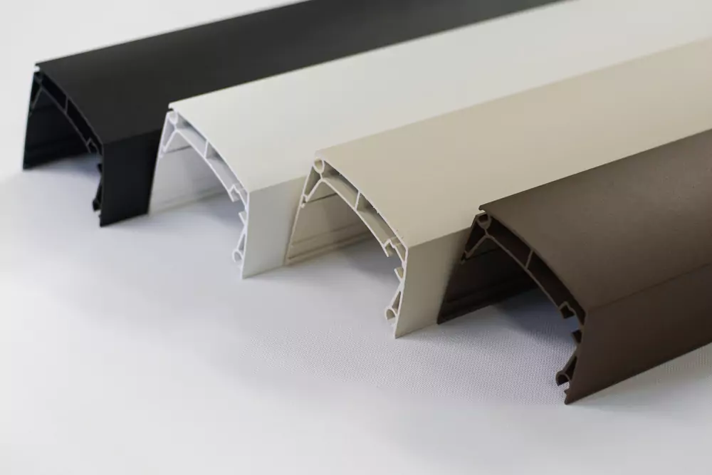 Barvni vzorci aluminijastih profilov za senčila – črna, bela, bež in rjava – prikazani na beli podlagi.