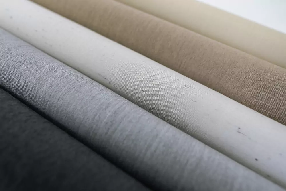 Različni vzorci in barve visokokakovostnih tkanin za tende – od temno sive do svetlo bež odtenkov.
