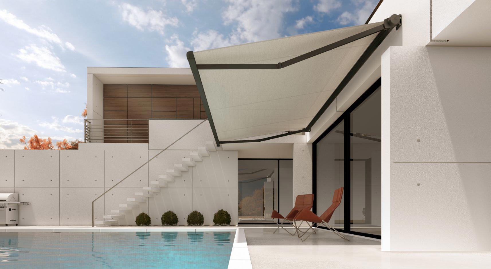 Sodobna odprta kasetna tenda z antracitnim ogrodjem in svetlim platnom, nameščena nad teraso ob bazenu moderne bele hiše.
